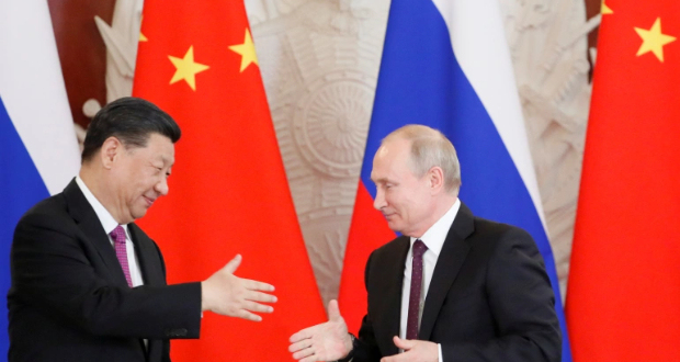 Russian President Vladimir Putin attempts to shake hands with his Chinese counterpart Xi Jinping during a meeting in Moscow, Russia, June 5, 2019 [File: Evgenia Novozhenina/ Reuters]
