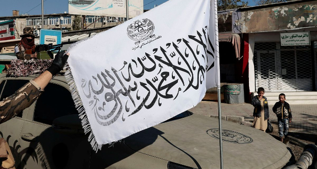 A Taliban fighter displays their flag as his comrade watches, at a checkpoint in Kabul, Afghanistan November 5, 2021. REUTERS/Zohra Bensemra