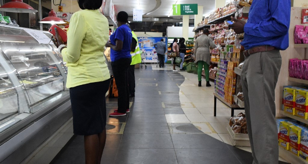 Customers stand in squares marked on the floor indicating safer spaces in queues as they shop at a supermarket, while they stock their homes amid concerns about the spread of the Covid-19 outbreak in Nairobi, Kenya, on March 30, 2020 AFP