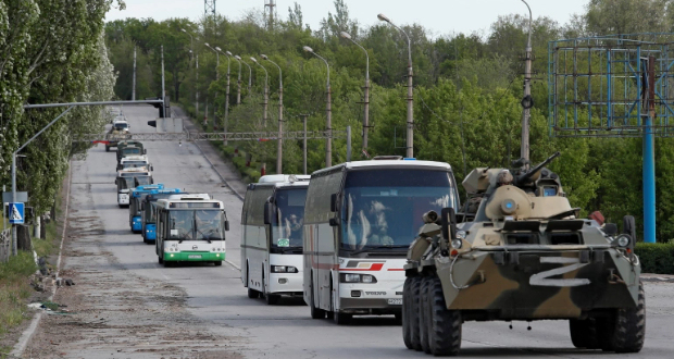 Buses carrying Ukrainian service members who have surrendered after weeks holed up at the Azovstal steelworks drive away under the escort of the pro-Russian military in Mariupol, Ukraine on May 17, 2022 [Alexander Ermochenko/Reuters]