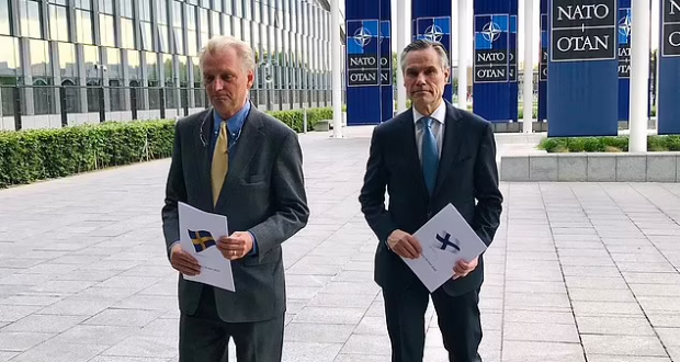 Axel Wernhoff and Klaus Korhonen, the Swedish and Finnish ambassadors to NATO, carry letters of application into their meeting with Jen Stoltenberg in Brussels