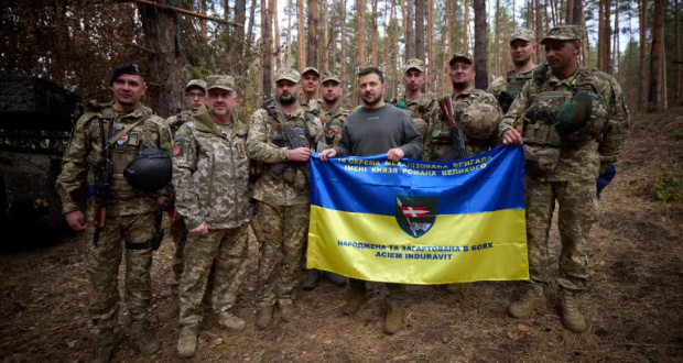 Ukraine's President Volodymyr Zelenskiy poses for a picture with service members as he visits a position of Ukrainian troops in a front line [Ukrainian Presidential Press Service via Reuters]