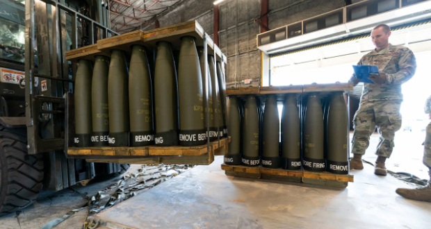 In this April 2022 photo, US Air Force Staff Sgt. Cody Brown, right, with the 436th Aerial Port Squadron, checks pallets of 155 mm shells ultimately bound for Ukraine, at Dover Air Force Base, Delaware.