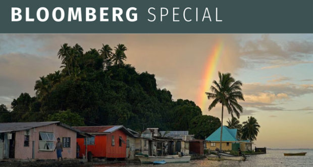 Local resident Tarusila Boseiwaqa walks along a sea wall that no longer protects homes from the intrusion of water at higher tides, as a rainbow forms over Serua Village, Fiji, July 14, 2022. Photo: Reuters