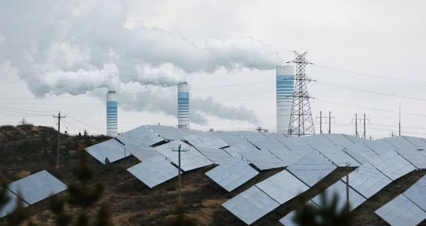 Smoke rises from chimneys near solar panels, during a Huawei-organised media tour, in Shaanxi province, China April 24, 2023. REUTERS/Tingshu Wang/File Photo