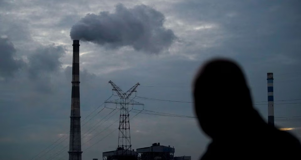 A man walks past a coal-fired power plant in Shanghai, China, October 14, 2021. REUTERS/Aly Song/File Photo