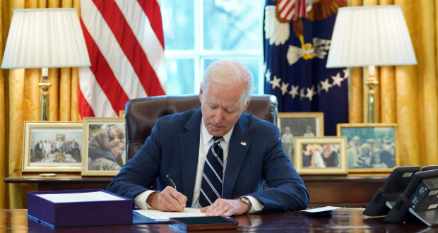 US President Joe Biden signs the American Rescue Plan on March 11, 2021, in the Oval Office of the White House in Washington, DC.
