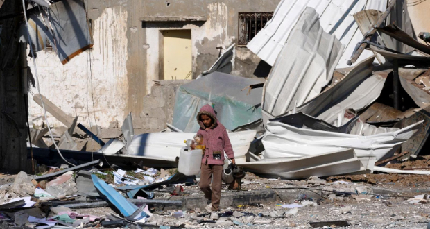 A Palestinian child walks past factories destroyed in the Israeli bombardment of the Gaza Strip in Deir al Balah on Saturday, Jan. 13, 2024. (AP Photo/Adel Hana)