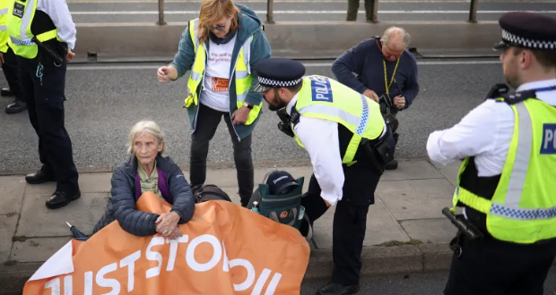 A police officer speaks with a person from 'Just Stop Oil' protesting in London, UK, October 2, 2022 [File: Henry Nicholls/Reuters]